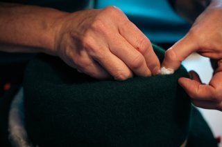 Annick Roulet en plein travail de fixation du feutre sur son moule